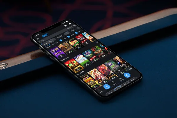 A young woman relaxing with her phone while dynamic casino elements float around her, illustrating the smooth mobile experience offered by the DBTJL app.