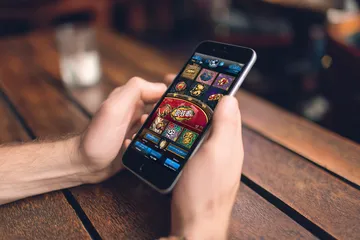 A cheerful woman in traditional clothing using her smartphone during a festive moment, showing how easily the DBTJL app fits into everyday life.