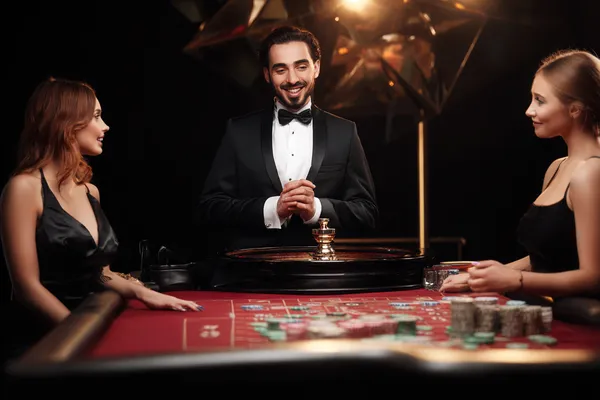 A woman in a luxurious green gown next to an ornate roulette wheel, capturing the upscale casino mood of DBTJL.